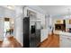Open kitchen featuring white cabinetry, stainless steel appliances, and hardwood floors at 1904 Victoria Rd, Raleigh, NC 27608