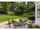 Backyard stone patio with patio seating surrounded by lush gardens at 1904 Victoria Rd, Raleigh, NC 27608