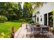 Stone patio with an outdoor dining area and a view of the lawn and gardens at 1904 Victoria Rd, Raleigh, NC 27608