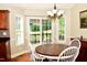 Bright dining area with bay window, sliding glass door, wood floors and classic chandelier at 1980 Ferbow St, Creedmoor, NC 27522