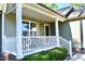 Inviting front porch featuring white railing, brick foundation, and a cozy seating area at 1980 Ferbow St, Creedmoor, NC 27522