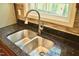 Kitchen sink features a stainless steel dual basin and a goose-neck faucet, plus a window view at 1980 Ferbow St, Creedmoor, NC 27522
