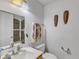 Bathroom with a toilet, sink and towel rack, including two decorative masks hanging on the wall at 2010 Summerdale Dr, Raleigh, NC 27604