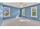 Sunlit bedroom featuring three windows, ceiling fan, and neutral carpet, creating a serene living space at 2037 Summer Shire Way, Raleigh, NC 27604