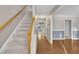 Hallway with hardwood floors, carpeted stairs, and neutral paint creating an inviting space at 2037 Summer Shire Way, Raleigh, NC 27604