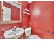 Powder room featuring red walls, modern sink, white toilet and decorative mirror at 2037 Summer Shire Way, Raleigh, NC 27604