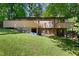 Back of house featuring upper and lower decks, landscaping, and wooded area at 205 Bruton Dr, Chapel Hill, NC 27516