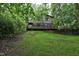 View of the home's backyard, showcasing a lush lawn and wooded surroundings at 205 Bruton Dr, Chapel Hill, NC 27516