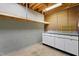 Unfinished basement features concrete floor and walls, shelving, and work bench at 205 Bruton Dr, Chapel Hill, NC 27516