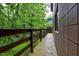Side deck with wooden planks and wooden railing overlooks the lush green landscape at 205 Bruton Dr, Chapel Hill, NC 27516