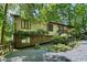 Exterior view of home featuring gravel driveway and lush green foliage all around at 205 Bruton Dr, Chapel Hill, NC 27516