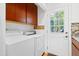 Laundry area with washer, dryer, and cabinets for storage with exterior access at 205 Bruton Dr, Chapel Hill, NC 27516