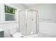 Bright bathroom with a glass enclosed shower, white toilet, and a window for natural light at 206 Lilliput Ln, Wake Forest, NC 27587