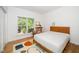 Bright bedroom featuring hardwood floors, a window view, and a contemporary design at 206 Lilliput Ln, Wake Forest, NC 27587