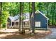 Charming blue two-story home featuring a welcoming front porch and mature landscaping with a wooded setting at 206 Lilliput Ln, Wake Forest, NC 27587