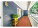 View of the spacious covered front porch with painted wood floor and white railings and columns at 206 Lilliput Ln, Wake Forest, NC 27587