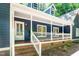 Covered front porch featuring brick steps and supports, white railings, and blue siding at 206 Lilliput Ln, Wake Forest, NC 27587