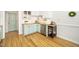 Corner view of a well-lit kitchen featuring stainless steel appliances, hardwood floors, and light mint green cabinets at 206 Lilliput Ln, Wake Forest, NC 27587