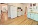A kitchen showcasing hardwood floors, white appliances, and cabinets in light mint green at 206 Lilliput Ln, Wake Forest, NC 27587