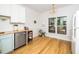 Bright kitchen area featuring hardwood floors, white walls, and a window with natural light at 206 Lilliput Ln, Wake Forest, NC 27587