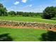 Serene view of stone wall, landscaped lawn, and walking path, blending nature's beauty at 206 Lilliput Ln, Wake Forest, NC 27587