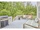 Inviting back deck with outdoor kitchen, comfortable seating, and wooded backdrop at 210 Bennington Pkwy, Durham, NC 27713