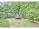 Large backyard featuring a trampoline, surrounded by mature trees for privacy at 210 Bennington Pkwy, Durham, NC 27713