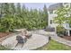 Backyard oasis featuring a fire pit, hot tub, hammock, and lush, mature landscaping at 210 Bennington Pkwy, Durham, NC 27713
