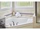 Bathroom showing a soaking tub with decorative tiling and natural light at 210 Bennington Pkwy, Durham, NC 27713