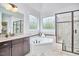 Elegant bathroom featuring a soaking tub, glass shower, and dark wood cabinetry at 210 Bennington Pkwy, Durham, NC 27713