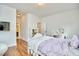 Bedroom with white walls, wood floors, and TV; a door leads to the bathroom at 210 Bennington Pkwy, Durham, NC 27713
