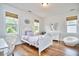 Bright bedroom features hardwood floors, white furniture, and three large windows at 210 Bennington Pkwy, Durham, NC 27713