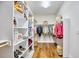 Organized walk-in closet with shelving, hanging rods, and hardwood floors at 210 Bennington Pkwy, Durham, NC 27713