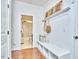 Mud room with built-in bench, wood floors, and entry to the bright white bathroom at 210 Bennington Pkwy, Durham, NC 27713