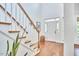 Bright and airy foyer featuring a white door, hardwood floors, and staircase at 210 Bennington Pkwy, Durham, NC 27713