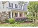 Charming covered front porch with beautiful landscaping and a red front door at 210 Bennington Pkwy, Durham, NC 27713