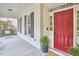 Charming front porch featuring a porch swing, red door, and classic brick accents at 210 Bennington Pkwy, Durham, NC 27713