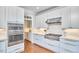 Well-equipped kitchen with stainless steel appliances, white cabinetry, and stylish range hood at 210 Bennington Pkwy, Durham, NC 27713