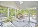 Screened porch with comfortable seating and a peaceful wooded view at 210 Bennington Pkwy, Durham, NC 27713