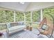 Screened porch with comfortable seating and a peaceful wooded view at 210 Bennington Pkwy, Durham, NC 27713