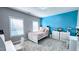 Stylish bedroom with a vibrant blue accent wall, white furniture, and plenty of natural light at 232 Hensley Hill Pl, Holly Springs, NC 27540
