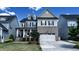 Well-maintained two-story home featuring a two-car garage, manicured lawn, and classic architectural details at 232 Hensley Hill Pl, Holly Springs, NC 27540