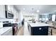 Bright kitchen showcasing an island with seating, white countertops and cabinets, and stainless steel appliances at 232 Hensley Hill Pl, Holly Springs, NC 27540