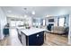 Open-concept kitchen with large island, seating, and a view of the living area with fireplace at 232 Hensley Hill Pl, Holly Springs, NC 27540