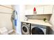 Laundry room featuring modern appliances, storage cabinets, and hanging rack at 232 Hensley Hill Pl, Holly Springs, NC 27540