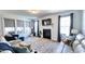 Open living space featuring fireplace and TV; large windows allowing natural light, and comfortable seating at 232 Hensley Hill Pl, Holly Springs, NC 27540
