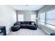 Inviting living room featuring a comfortable couch and bright natural light from the large windows at 232 Hensley Hill Pl, Holly Springs, NC 27540