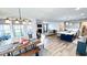 Open-concept living space with hardwood floors, dining area, modern kitchen, and cozy living room with fireplace at 232 Hensley Hill Pl, Holly Springs, NC 27540
