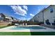 Inviting backyard pool features a tanning ledge, lush artificial turf, and easy access to the home's deck at 232 Hensley Hill Pl, Holly Springs, NC 27540