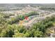 Overhead shot showcasing a community with beautiful homes, mature trees, and a serene pond near the property at 3034 Raddercrest Ct, Fuquay Varina, NC 27526